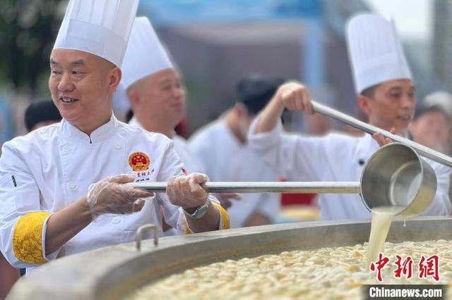 5月16日，厨师向游客展示奶白鲜香的肥鱼汤。郭晓莹 摄 