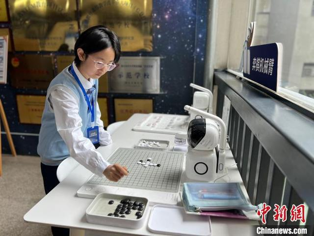 16日，南京市科利华中学学生手执黑子，与机器人棋盘对弈。中新网记者 朱晓颖 摄