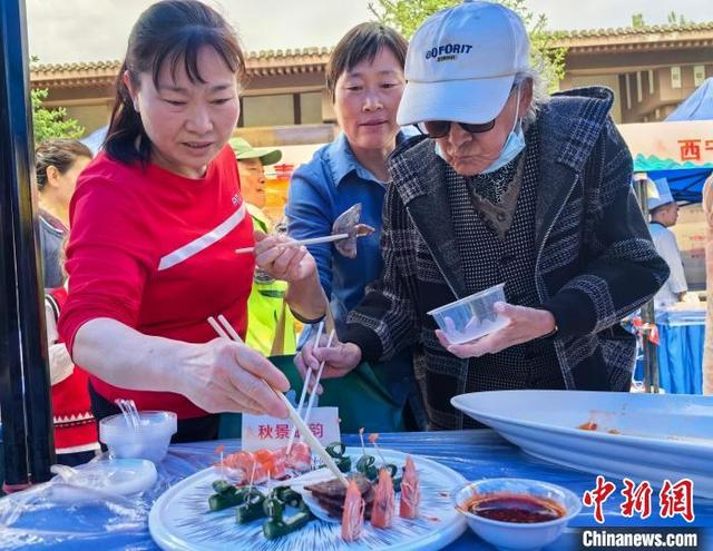 图为民众品尝“老八盘”菜品。祁增蓓 摄