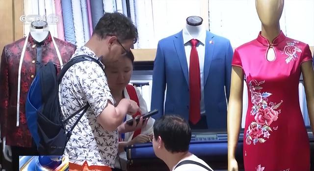 不少外国游客还专程来定制一套中式礼服（来源：央视新闻）