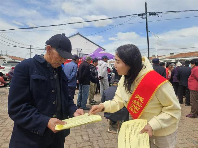 向村民发放宣传资料。（资料图）