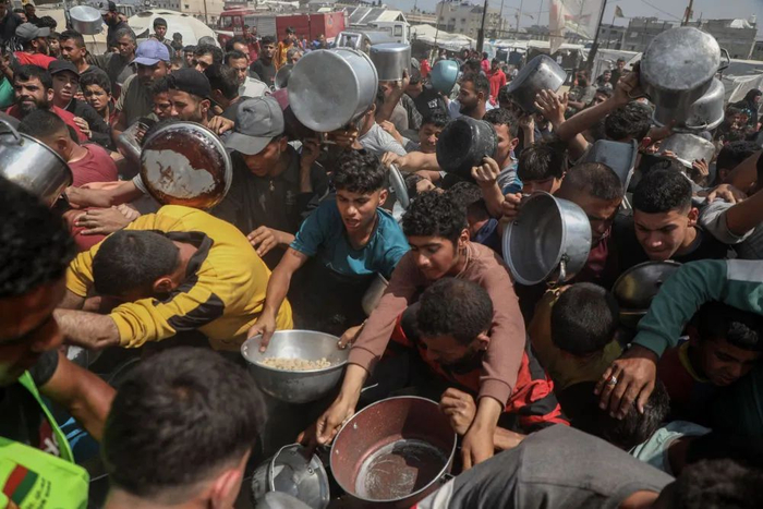 5月2日，人们在加沙城领取救助食物。新华社发（里泽克·阿卜杜勒贾瓦德摄）