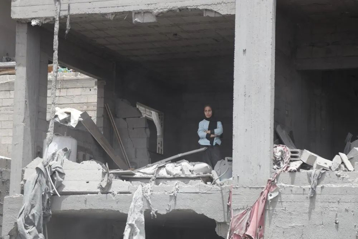 5月17日，在加沙地带北部杰巴利耶难民营，一名女子站在破损的房屋中。新华社发（阿卜杜勒拉赫曼·萨拉马 摄）