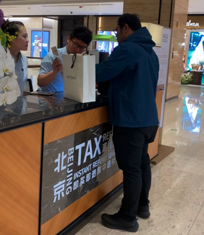 （境外旅客在王府中環集中退付点咨询“即买即退”业务 郭博昊/摄）