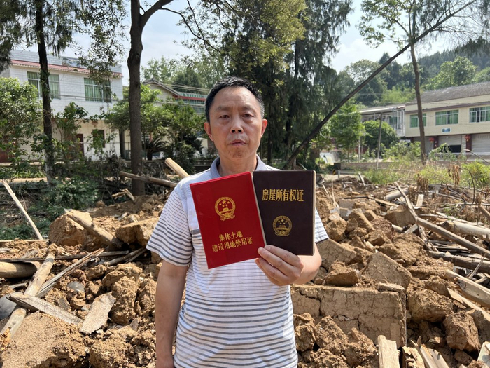 杨清虎出示他的《房屋所有权证》和《集体土地建设用地使用证》。图片来源：澎湃新闻记者 胥辉 摄