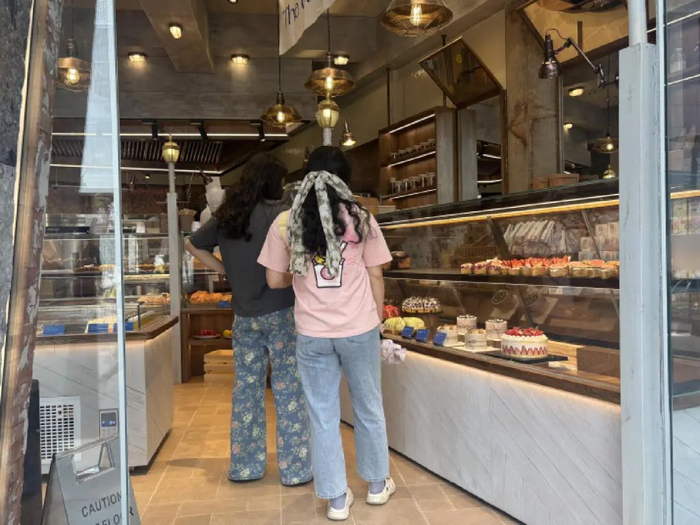顾客在烘焙店内选购面包甜点
