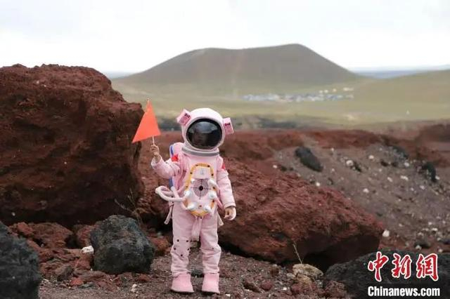 图为身着宇航服的小朋友在乌兰哈达火山打卡。中新社记者 张林虎 摄