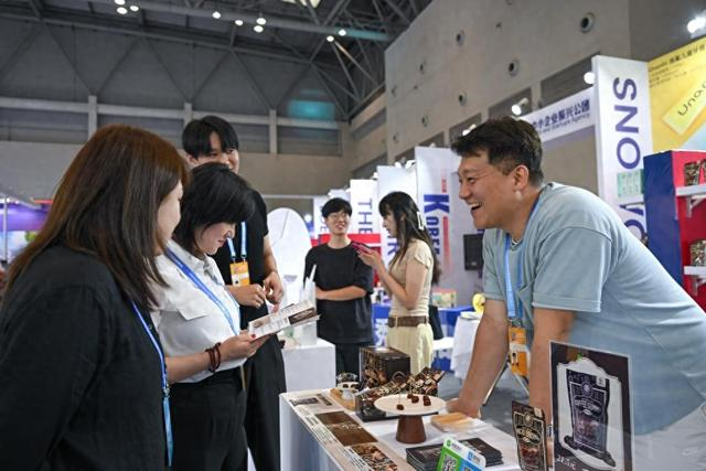 5月22日，韩国展商（右一）在西洽会现场向参观者介绍产品。新华社记者 陈诚 摄