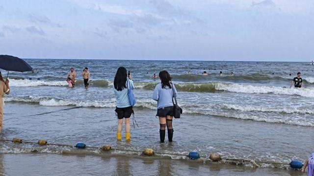 5月22日傍晚，游客在茂名“中国第一滩”打卡拍照。 澎湃新闻记者 王岱玉 图