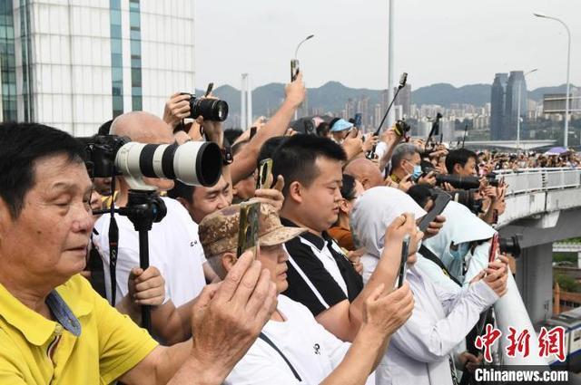 图为市民外出围观重庆站华铁宾馆被爆破拆除。中新社记者 周毅 摄