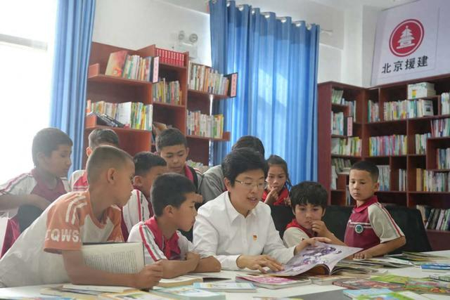 高超在皮山农场“昆泉润心护苗”党建品牌职工书屋内带着青少年一起阅读科普书籍。（本人供图）