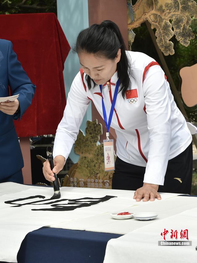 图为北京2008年奥运会女子柔道78公斤级冠军杨秀丽正在书写墨宝。韦俊龙 摄