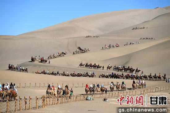 5月24日，游客在敦煌市鸣沙山月牙泉景区游览。张晓亮 摄