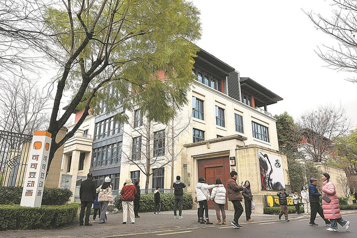     影迷们在成都可可豆动画影视有限公司前打卡。 图据新华社