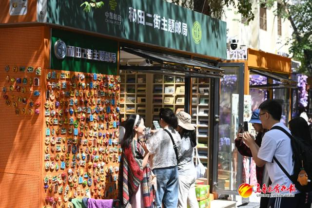 图为：5月28日，在乌鲁木齐市和田二街主题邮局，游客正在拍照留念。