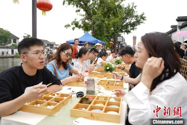 5月31日，浙江南浔，游客体验品尝长街宴传统美食。南浔区委宣传部供图