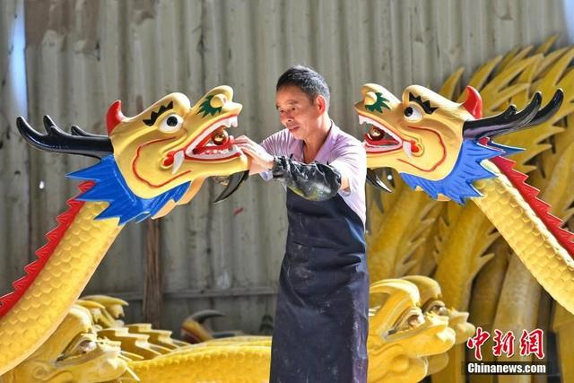 屈子祠镇一龙舟厂内，工人为龙头安装龙珠。杨华峰 摄