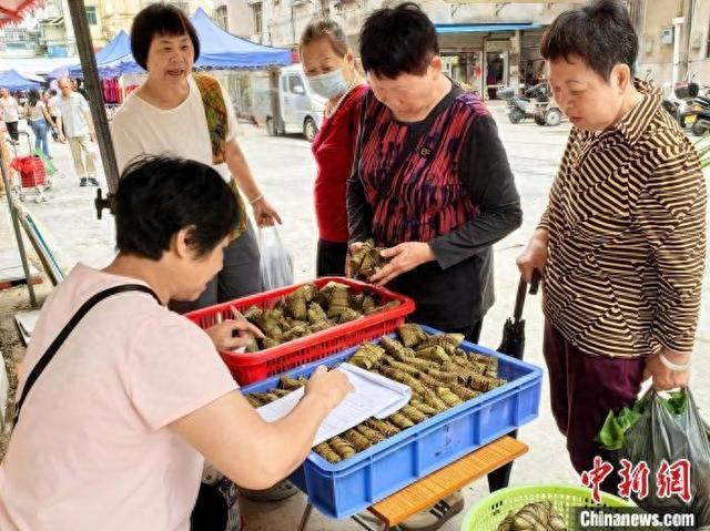 5月25日，广东台山市，台城街道富城市场一档口的负责人在接受市民订购灰水粽。李晓春 摄