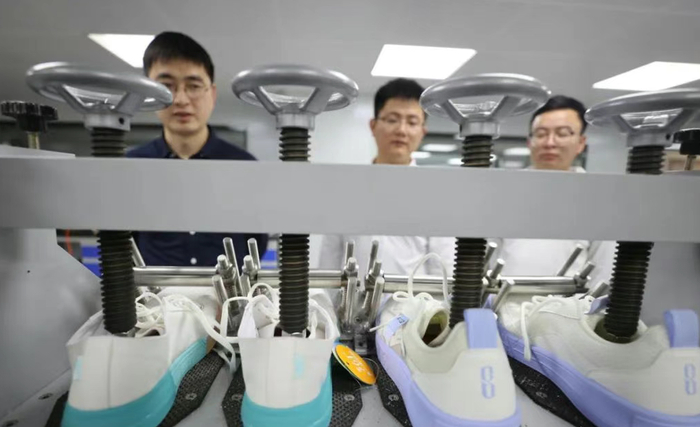 ▲在中国皮革和制鞋工业研究院（晋江）有限公司实验室里，工作人员正在鞋样进行疲劳老化实验。图源：泉州通客户端