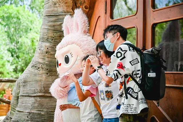 游客在泡泡玛特城市乐园与人偶互动。企业供图