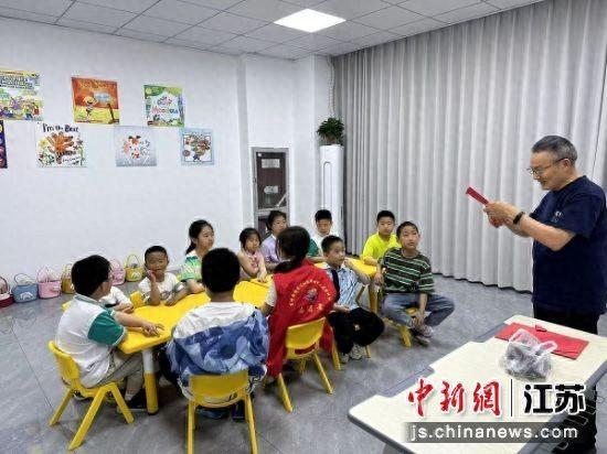 非遗代表性传承人向孩子们介绍剪纸艺术。东坎街道供图