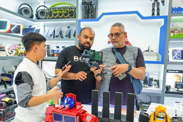 4月15日，浙江金华，在义乌国际商贸城，外国游客在与商户洽谈、采购中国电子产品。视觉中国供图