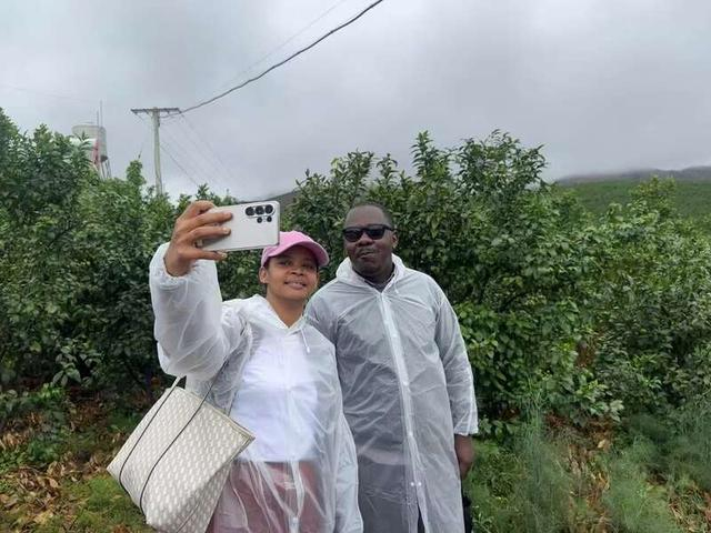 农创客训练营成员们在大理宾川柑橘科技小院示范园中与果树自拍，记录自己在中国的调研之旅。中青报·中青网记者贺瑶/摄