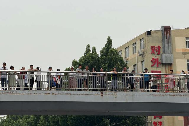 6月7日，河南省实验中学门口的过街天桥上，站满了前来送考的家长。中青报·中青网见习记者 李梓昂/摄