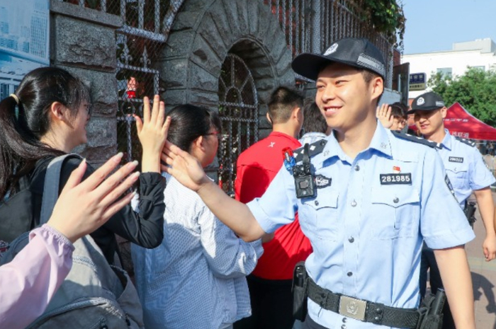 天津七中考点外，警号尾数985的警察在为考生加油。陈欣然 摄