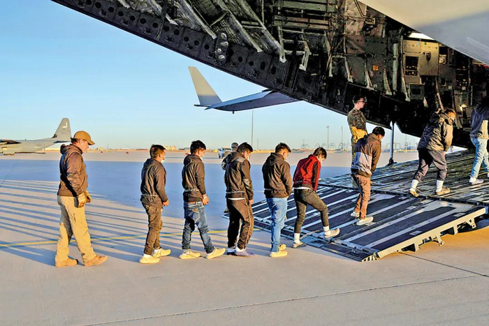 特朗普政府公布美国执法人员在得 克萨斯州押送戴着手铐和脚镣的非法移民上飞机的照片