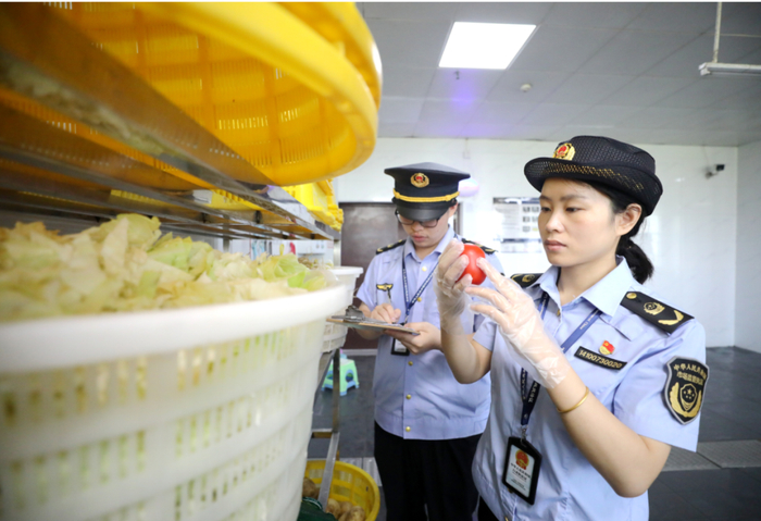 江西省吉安市峡江中学考点食堂，市场监督管理局工作人员在对蔬菜进行检查。通讯员 宋靖辉 摄
