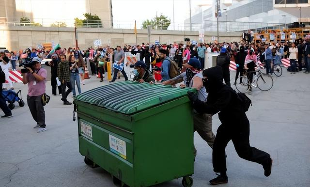 示威者推动垃圾桶试图阻挡执法人员去路 图/路透社