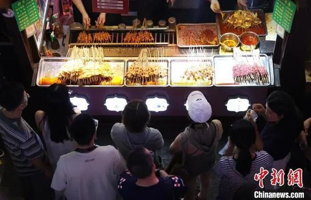 市民游客在怀远夜市购买美食。于晶 摄