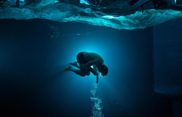 宗教性的裸体婴儿状预示新生/被营救，实则牵强附会于男主深海裸泳上浮逃生叙事。