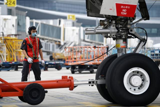 2021年7月21日，暑运期间，在天津滨海国际机场，天津航空的工作人员在进行飞机起飞前的准备工作。（新华社记者 李然 摄）