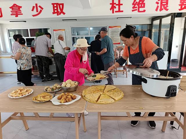 　　在呼伦贝尔市的长者食堂，工作人员为老人发餐。（自治区民政厅供图）