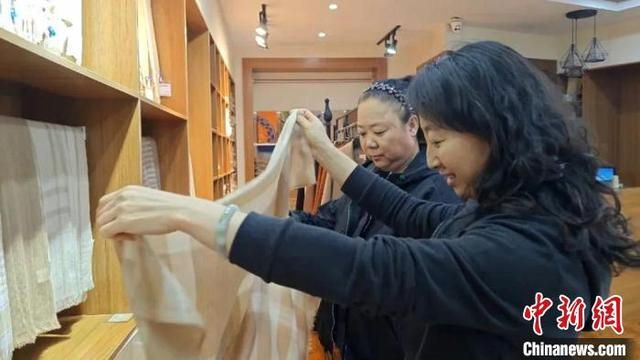 图为客商挑选驼绒制品。伟力思摄
