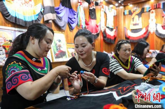 6月10日，在四川省马边彝族自治县马边花间刺绣专业合作社工作坊里，乔进双梅和绣娘一起交流刺绣技法。中新社记者 王磊 摄