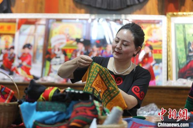 6月10日，在四川省马边彝族自治县马边花间刺绣专业合作社工作坊里，乔进双梅制作彝绣作品。中新社记者 王磊 摄