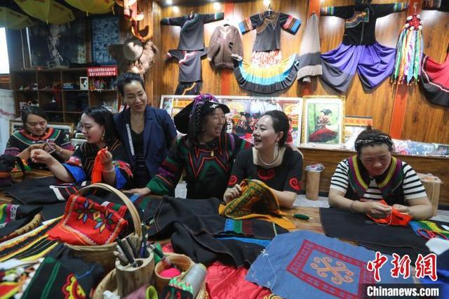 6月10日，在四川省马边彝族自治县马边花间刺绣专业合作社工作坊里，乔进双梅和绣娘们一边刺绣一边唱歌。中新社记者 王磊 摄