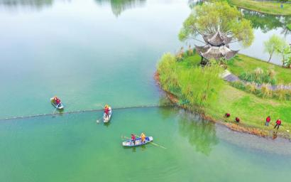 眉山市的志愿者在东坡城市湿地公园清理水面漂浮物、捡拾垃圾。姚永亮 摄（C视觉）
