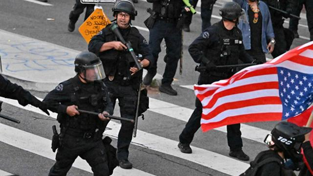 当地时间2025年6月10日，美国洛杉矶，在联邦移民行动引发数日抗议后，宵禁生效，防暴警察在街头清场。视觉中国 图