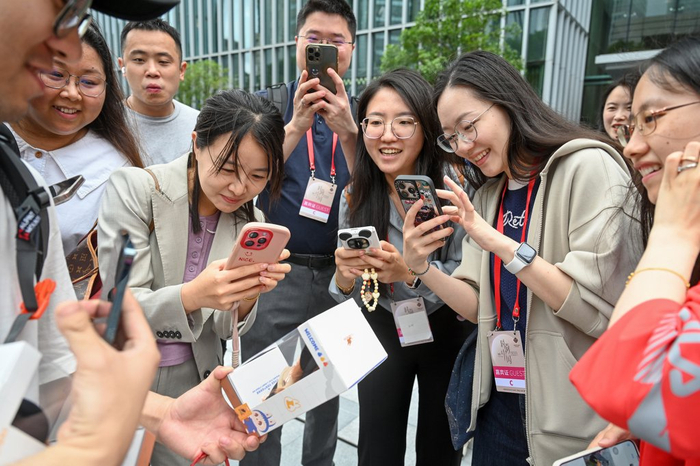 顾客展示刚提货的LABUBU搪胶毛绒吊卡，吸引了一群人围上来拍照。澎湃新闻记者 朱伟辉 图