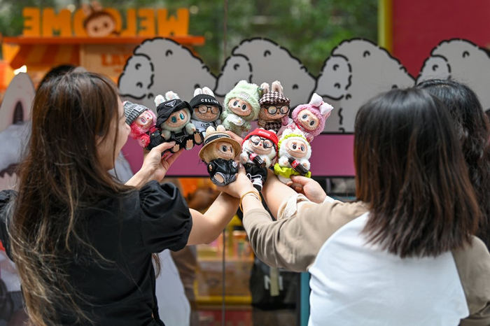 2025年6月13日，上海静安嘉里中心，女孩们在展示自己的LABUBU。澎湃新闻记者 朱伟辉 图