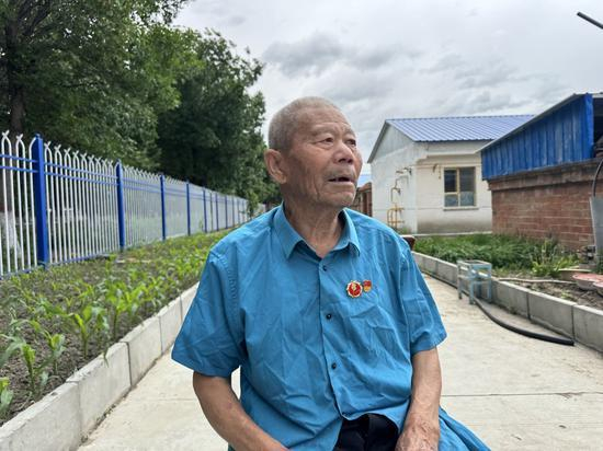 图为新疆生产建设兵团第十师185团蒋进文老人在家门口为记者讲述屯垦戍边的往事。冀江彤 摄