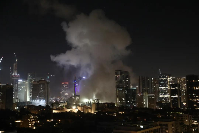 当地时间6月13日，在以色列特拉维夫，一栋大楼被导弹击中后升起浓烟。新华社发（吉德翁·马科维奇摄/基尼图片社）