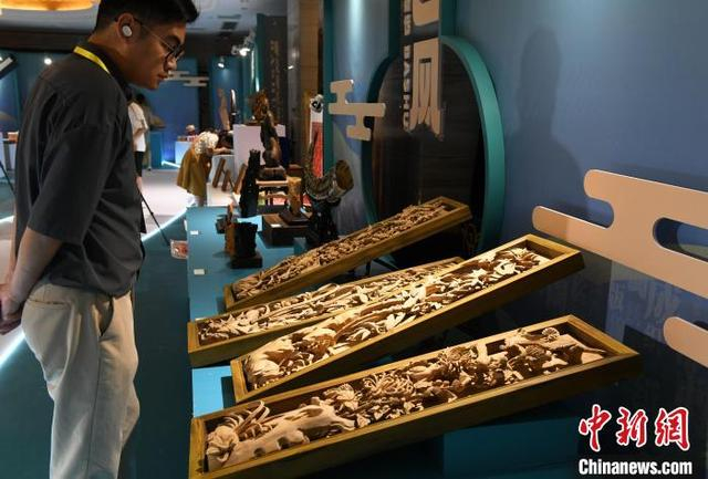 图为展览现场，周氏传统木作技艺作品《四季欣荣》吸引参观者眼球。中新社记者 周毅 摄 