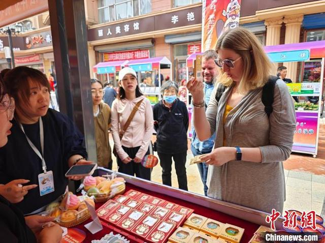 俄罗斯游客在非遗展销区选购手工艺品。 陈志伟 摄