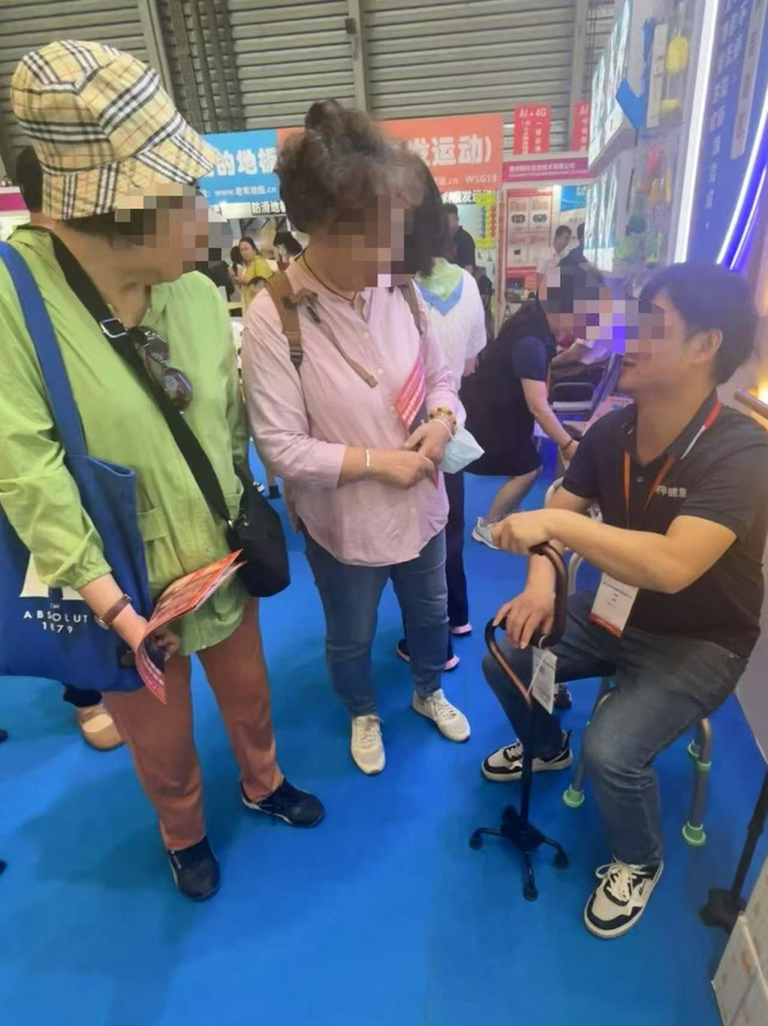 老人在研究老博会上一个拐杖的设计。