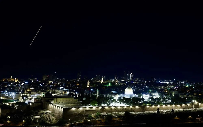 这是6月14日在耶路撒冷上空拍摄的导弹轨迹（左侧）。新华社发（贾马尔·阿瓦德摄）